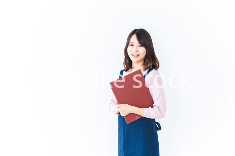 エプロンを着た家事代行の若い女性
