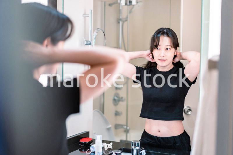 鏡の前で髪のセットをする若い女性