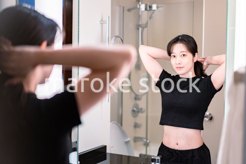 鏡の前で髪のセットをする若い女性