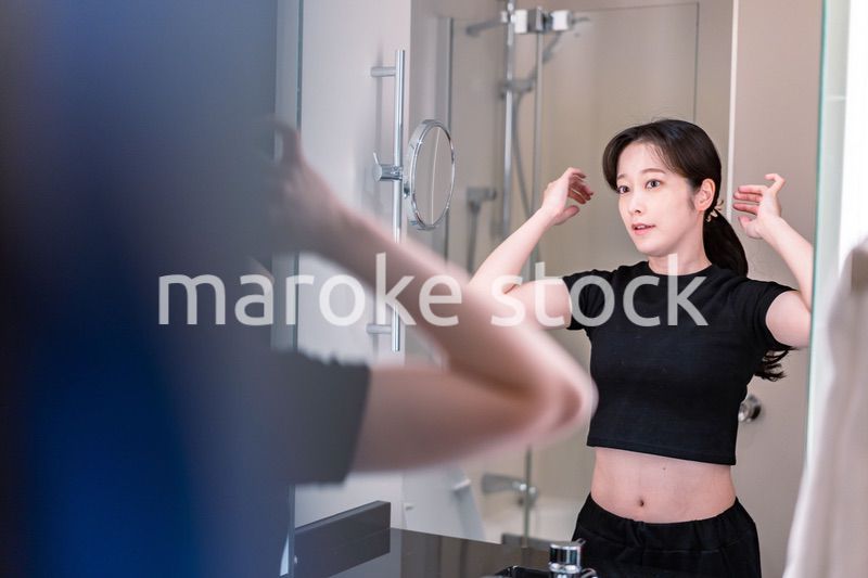 鏡の前で髪のセットをする若い女性