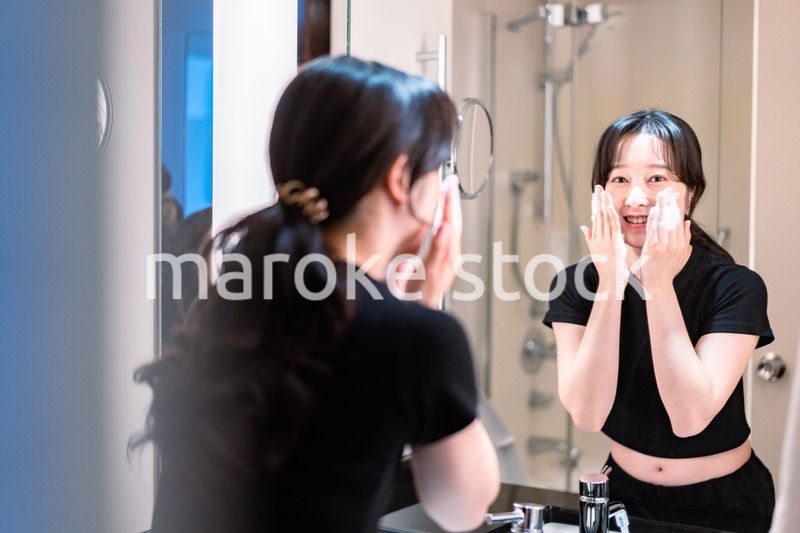 洗面所で洗顔をする若い女性