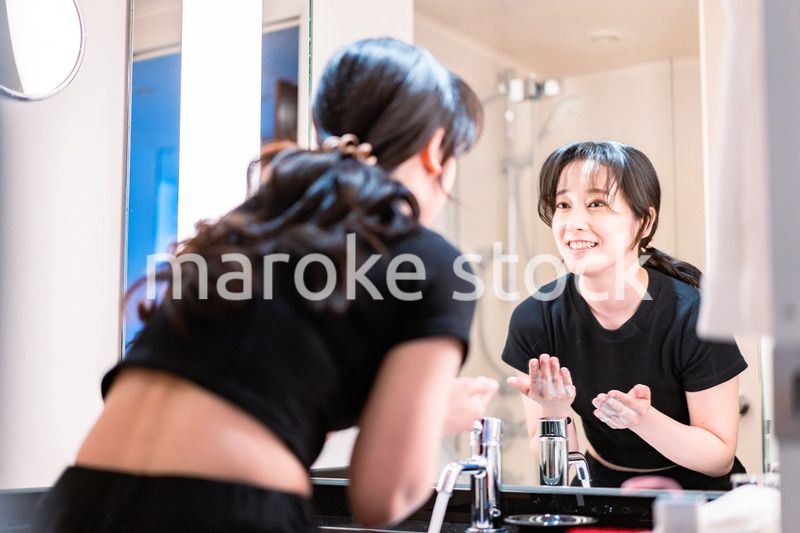 洗面所で洗顔をする若い女性