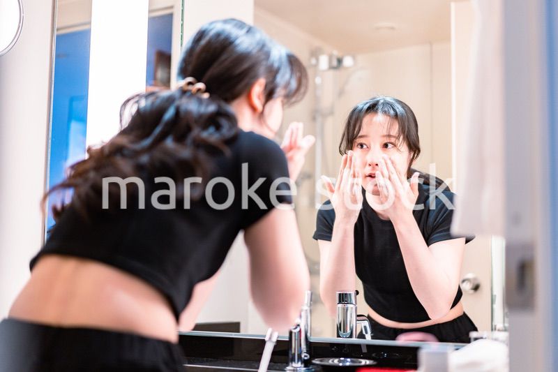 洗面所で洗顔をする若い女性