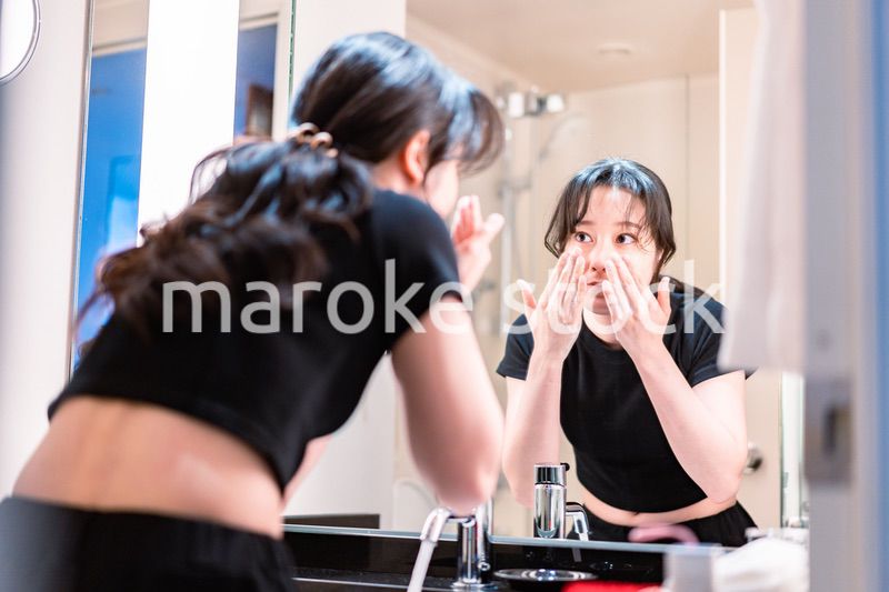 洗面所で洗顔をする若い女性