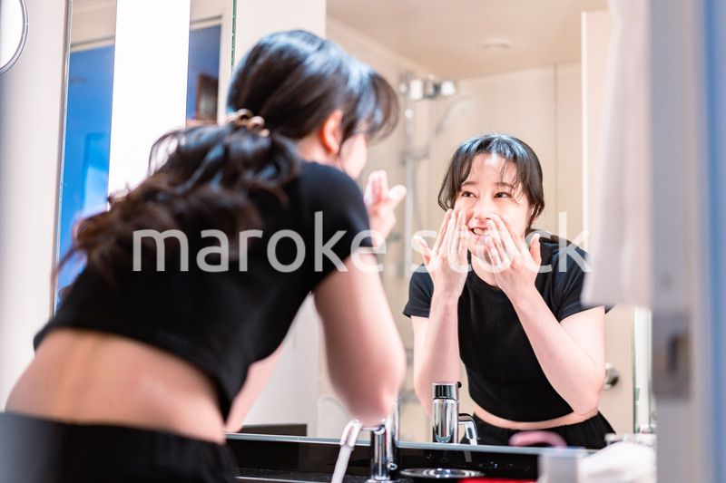 洗面所で洗顔をする若い女性