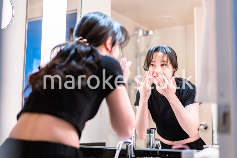 洗面所で洗顔をする若い女性