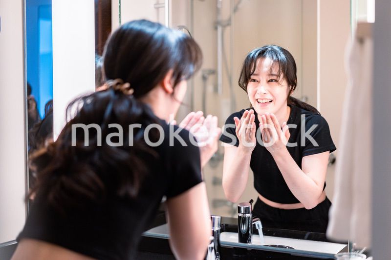 洗面所で洗顔をする若い女性