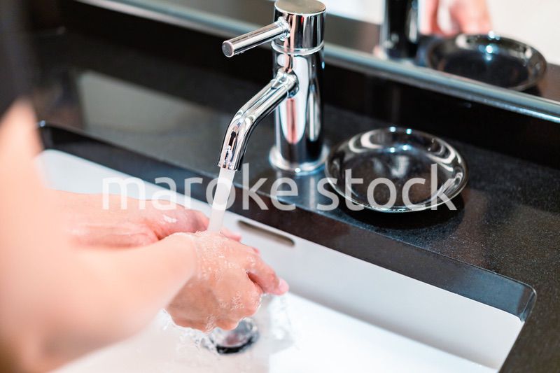 水道水で手を洗う若い女性