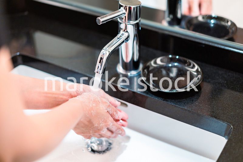 水道水で手を洗う若い女性