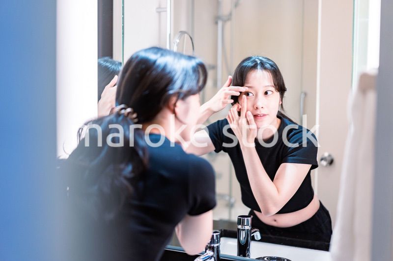 コンタクトレンズを装着する若い女性