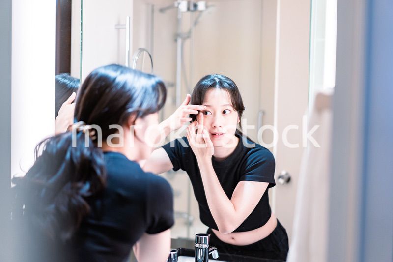 コンタクトレンズを装着する若い女性