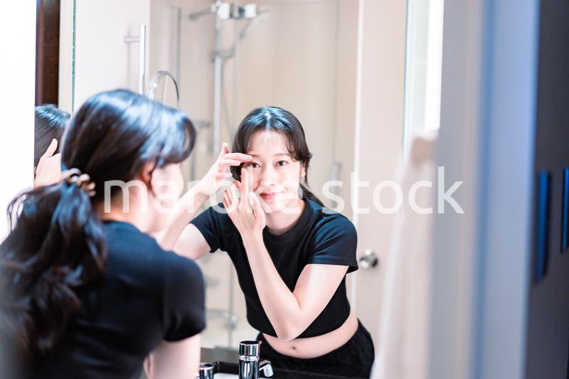 コンタクトレンズを装着する若い女性