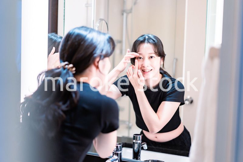 コンタクトレンズを装着する若い女性