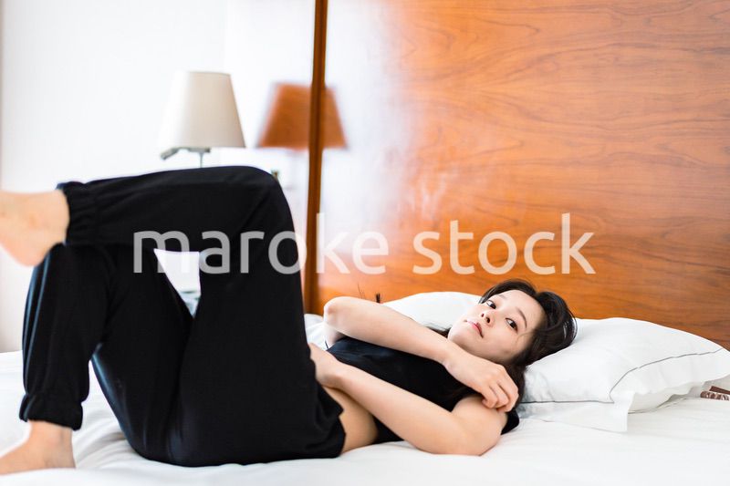 ベッドでストレッチをする若い女性