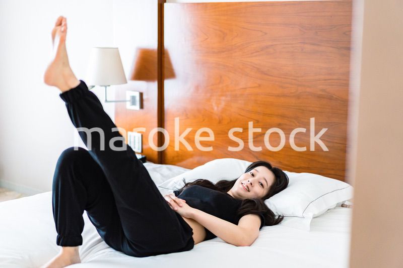 ベッドでストレッチをする若い女性