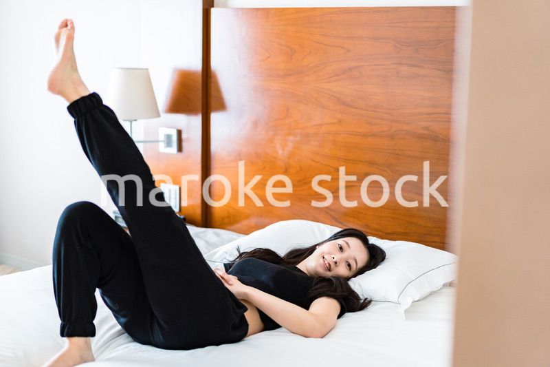 ベッドでストレッチをする若い女性