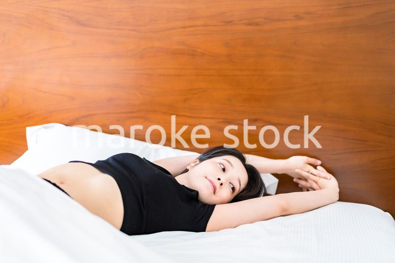 ベッドでストレッチをする若い女性