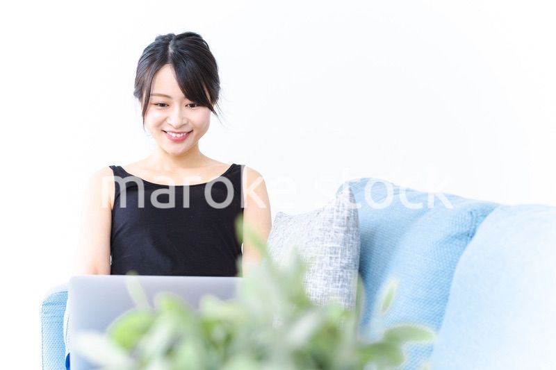 笑顔でパソコンを使う若い女性