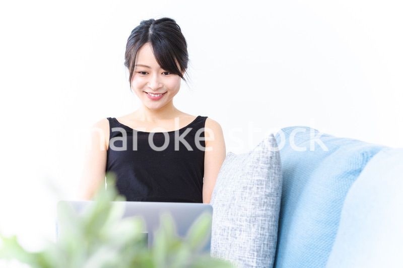 笑顔でパソコンを使う若い女性