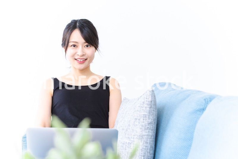 笑顔でパソコンを使う若い女性