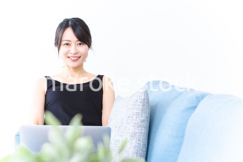 笑顔でパソコンを使う若い女性