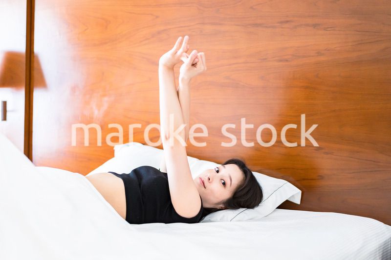 ベッドでストレッチをする若い女性