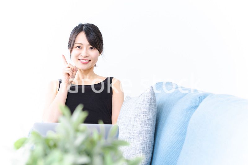 ソファに座っておすすめする若い女性