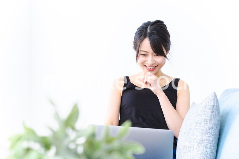 笑顔でパソコンを使う若い女性