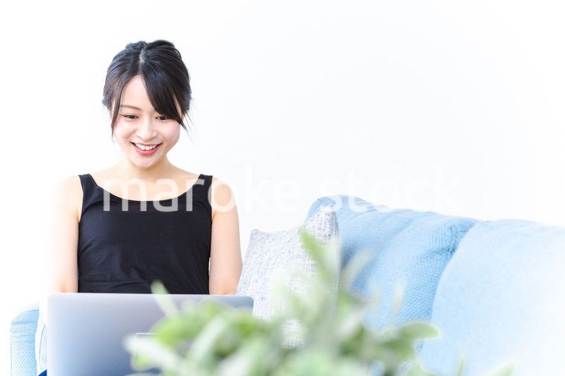 笑顔でパソコンを使う若い女性