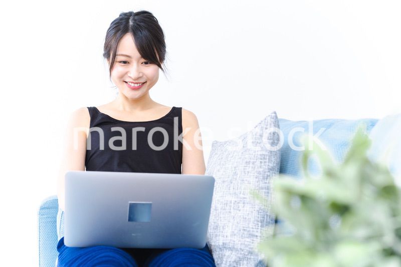 笑顔でパソコンを使う若い女性