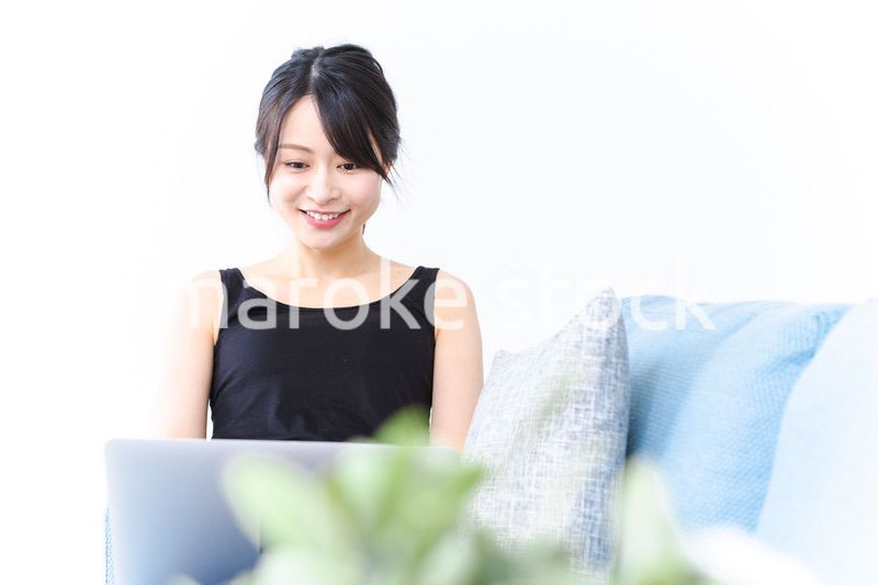 笑顔でパソコンを使う若い女性