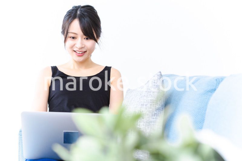 笑顔でパソコンを使う若い女性