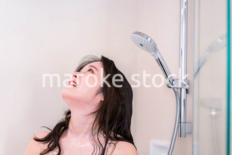 シャワーを浴びる若い女性