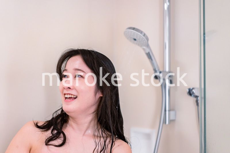 シャワーを浴びる若い女性