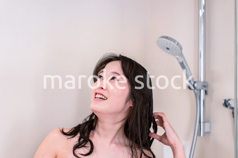 シャワーを浴びる若い女性