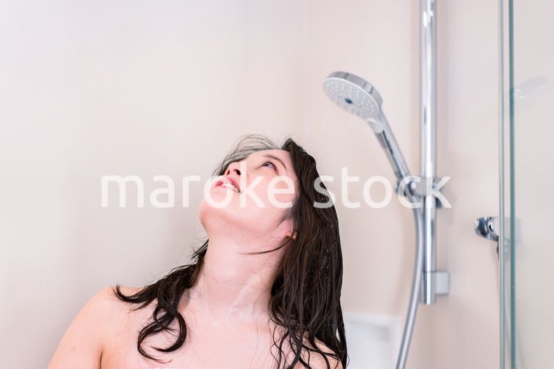 シャワーを浴びる若い女性