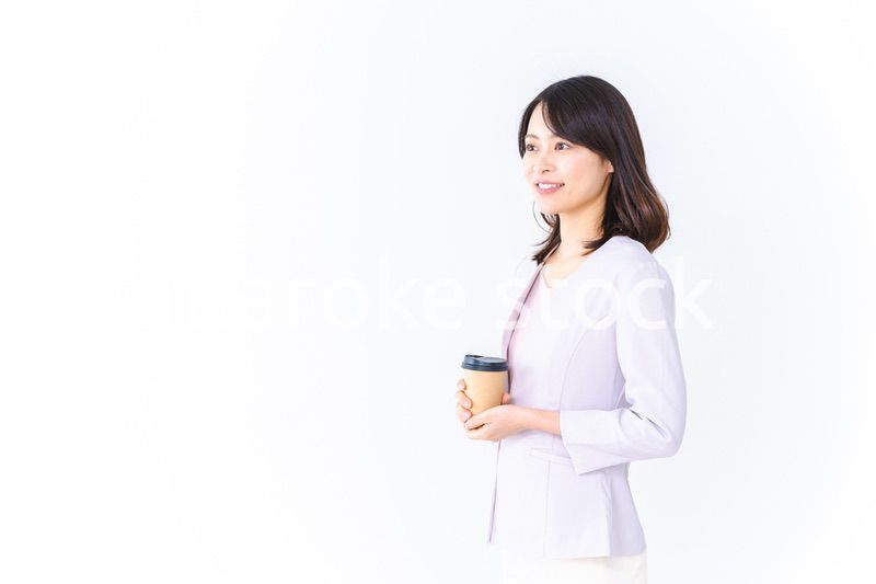 紙カップのコーヒーを飲むビジネスウーマン