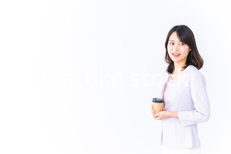 紙カップのコーヒーを飲むビジネスウーマン
