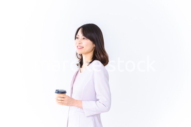 紙カップのコーヒーを飲むビジネスウーマン