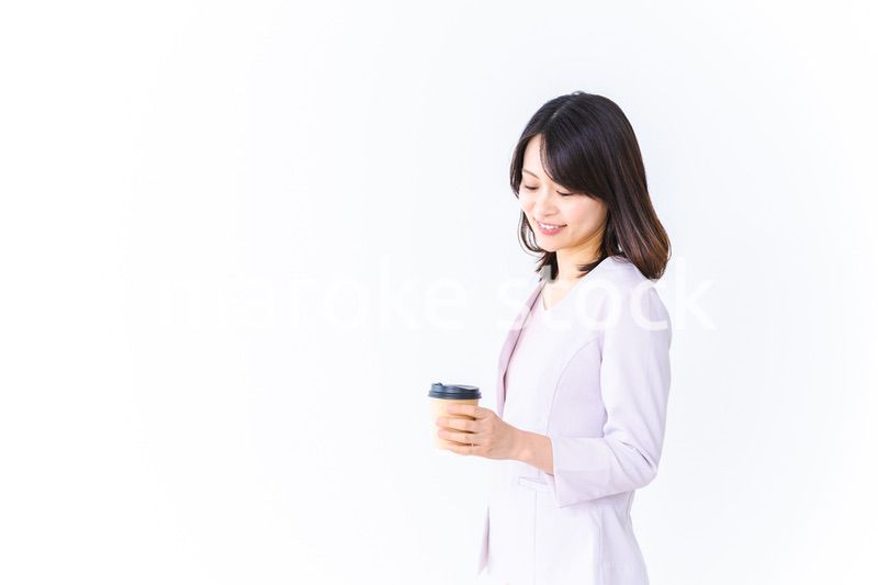 紙カップのコーヒーを飲むビジネスウーマン