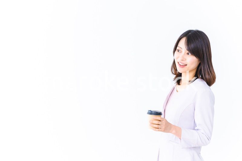 紙カップのコーヒーを飲むビジネスウーマン