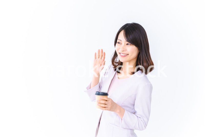 紙カップのコーヒーを飲むビジネスウーマン