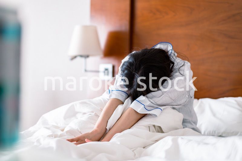 二日酔いに苦しむ若い女性