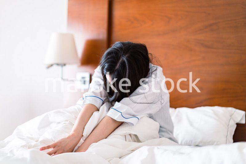二日酔いに苦しむ若い女性