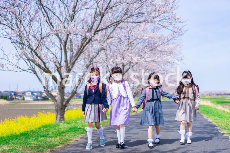 マスクをして小学校に登校する女の子たち