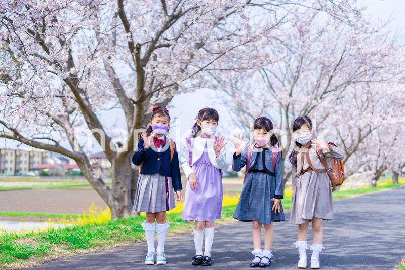マスクをして小学校に登校する女の子たち