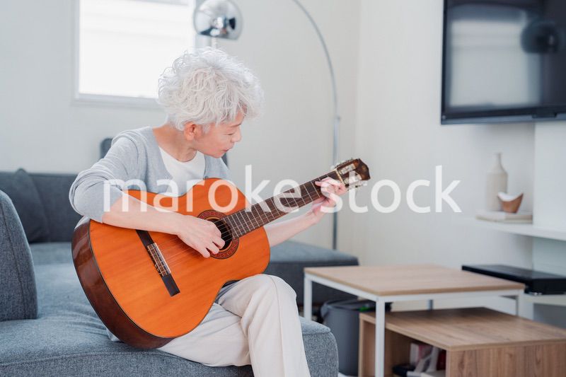 ギターを演奏するシニアの女性