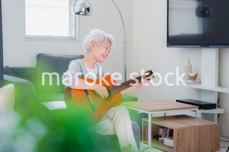 ギターを演奏するシニアの女性