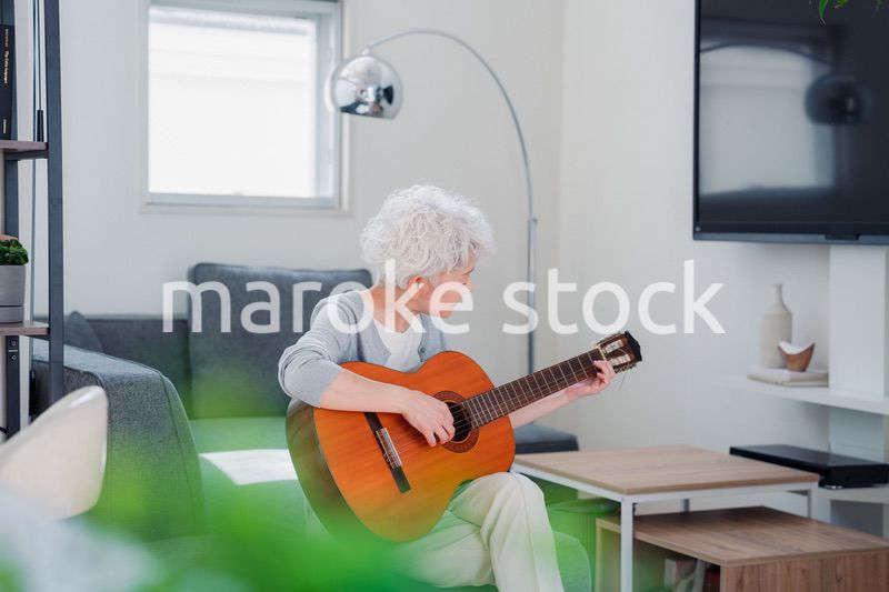 ギターを演奏するシニアの女性