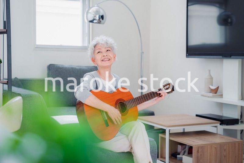 ギターを演奏するシニアの女性